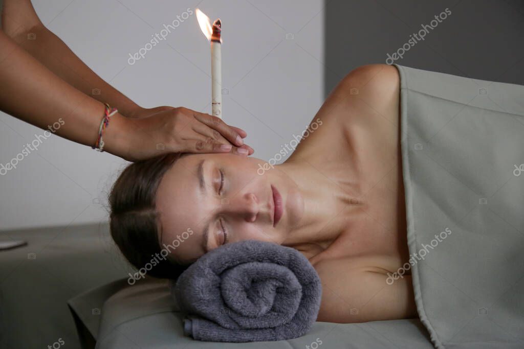 Ear candle therapy in a calm setting.