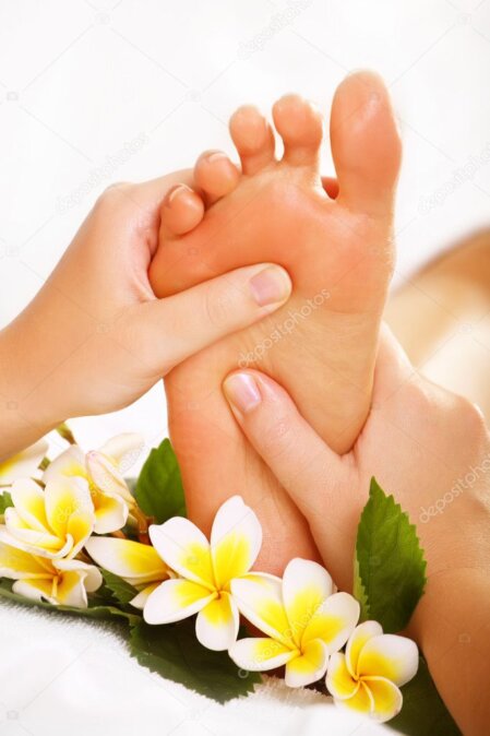 Therapist applying pressure to reflex points on the foot.